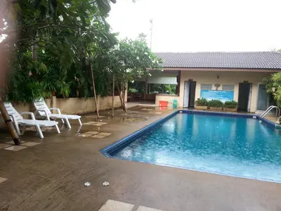 a swimming pool with chairs and a house at C.A.P Mansion in Phuket Town