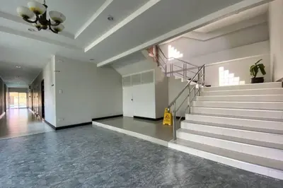 a lobby with a staircase with a yellow sign on it at C.A.P Mansion in Phuket Town
