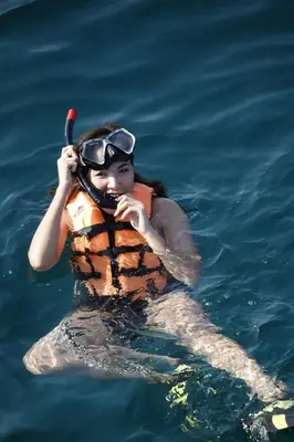 a woman in the water with a life vest and a paddle at Banhalawee in Ko Yao Yai