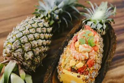 two pineapples with shrimp in them on a table at Banhalawee in Ko Yao Yai