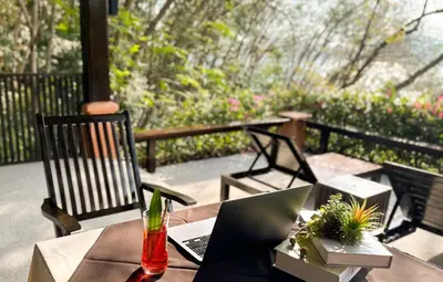 a table with a laptop computer on a patio at Korsiri Pool Villas in Panwa Beach
