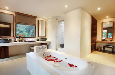 a bathroom with a tub with red flowers in it at Korsiri Pool Villas in Panwa Beach