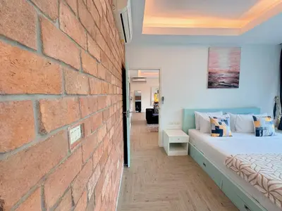 a bedroom with a brick wall next to a bed at Peaceful Bliss in 81sqm Top Floor in Kamala in Kamala Beach