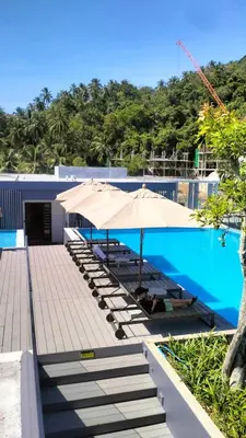 a pool with umbrellas and lounge chairs next to it at Cute Studio in Aristo Beach condo - 7 min walk to Surin Beach, construction view in Surin Beach