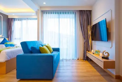 a bedroom with a blue chair and a bed at The Aristo Beach by Holy Cow, studio, without kitchen, construction view in Surin Beach