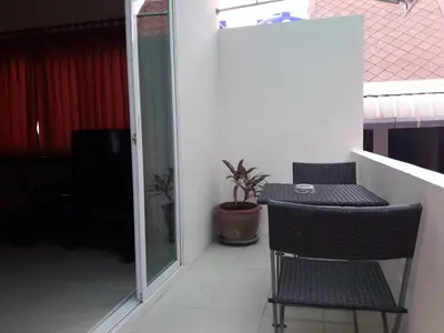 a balcony with a table and chairs in a room at Southern Fried Rice in Kata Beach