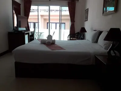 a bedroom with a bed with a stuffed animal on it at Southern Fried Rice in Kata Beach