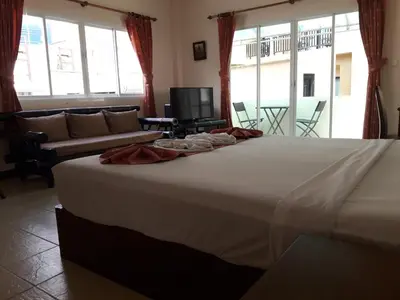 a large white bed in a room with a couch at Southern Fried Rice in Kata Beach