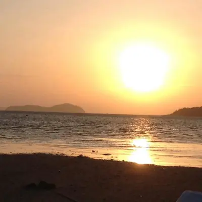 a sunset on the beach with the sun setting at C-VIEW BOUTIQUE in Rawai Beach