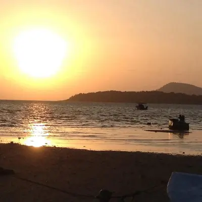 a sunset on the beach with boats in the water at C-VIEW BOUTIQUE in Rawai Beach