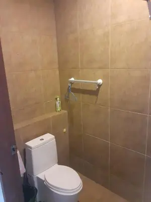 a bathroom with a toilet and a tiled wall at C-VIEW BOUTIQUE in Rawai Beach