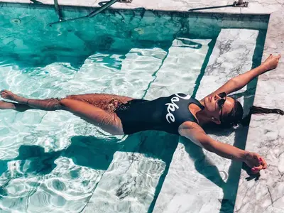 a woman laying in the water in a swimming pool at Grand Sunset Hotel Phuket in Karon Beach
