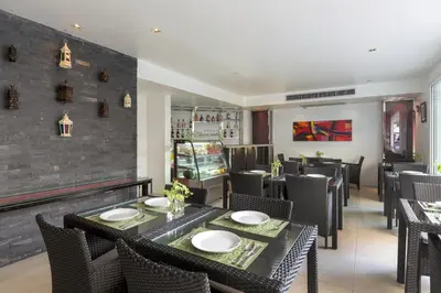 a dining room with a table and chairs at Grand Sunset Hotel Phuket in Karon Beach