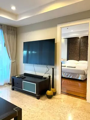 a living room with a large television and a bed at Bel Air Cape Panwa Resort Phuket in Panwa Beach