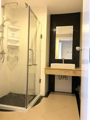 a bathroom with a glass shower and a sink at Bel Air Cape Panwa Resort Phuket in Panwa Beach