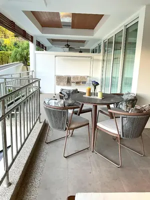 a patio with a table and chairs on a balcony at Bel Air Cape Panwa Resort Phuket in Panwa Beach