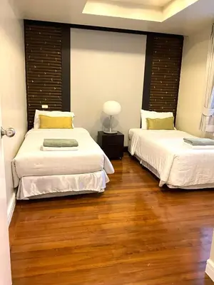 two beds in a room with wood flooring at Bel Air Cape Panwa Resort Phuket in Panwa Beach
