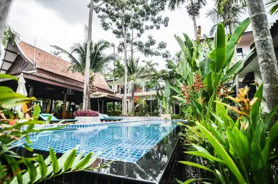 a swimming pool in a resort with trees and plants at Cocoville Phuket - SHA Plus in Chalong