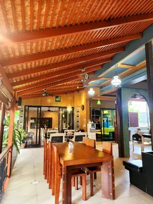 a dining room with a wooden table and chairs at Cocoville Phuket - SHA Plus in Chalong