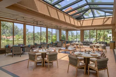 a dining room with tables and chairs and windows at Banyan Tree Phuket in Bang Tao Beach
