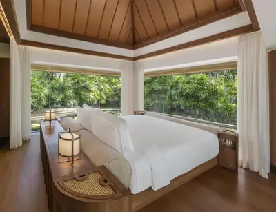 a bedroom with a large white bed and a large window at Banyan Tree Phuket in Bang Tao Beach