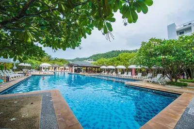 a pool at a resort with chairs and trees at Phuket Kata Resotel in Kata Beach