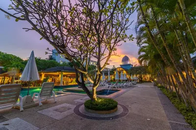 a courtyard with chairs and a tree and a mosque at Phuket Kata Resotel in Kata Beach