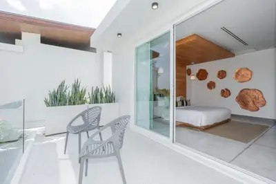 a room with a bed and a chair and a bedroom at Coastal Escape Natai Beach in Natai Beach