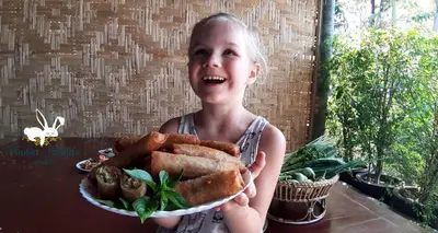 a young girl is holding a plate of food at Phuket Nonnita Boutique Resort - SHA Plus in Phuket Town