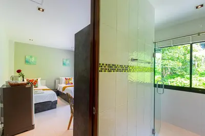 a bathroom with a shower and a bedroom at Rossarin Sea View Patong in Patong Beach