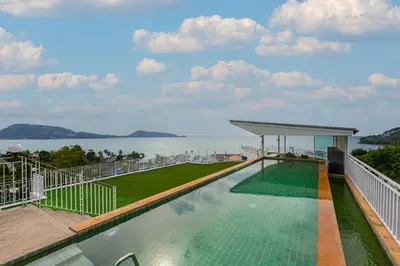 a swimming pool on a building with a view of the water at Rossarin Sea View Patong in Patong Beach