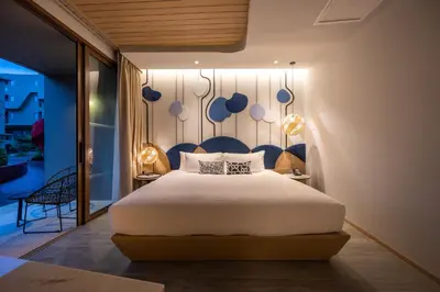 a bedroom with a large bed with a blue headboard at Metadee Concept Hotel in Kata Beach