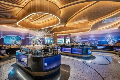 a bar in a hotel with blue walls and wood ceilings at Metadee Concept Hotel in Kata Beach
