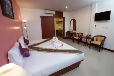 a hotel room with a bed with a towel on it at The BluEco Hotel SHA Plus in Kata Beach