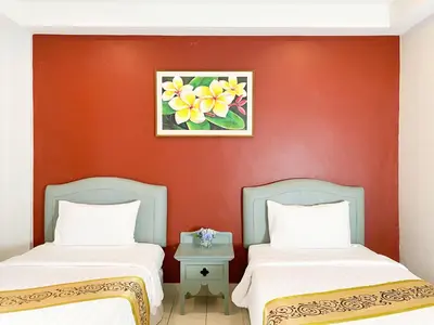 two beds in a room with a red wall at The Corner in Patong Beach