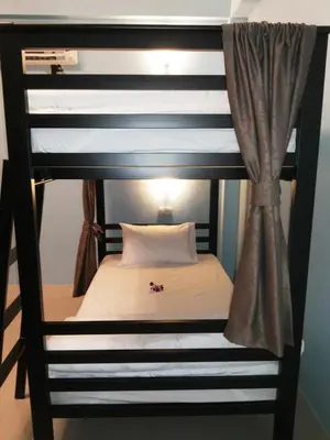 a bunk bed with a white pillow on top at One One Hostel Patong in Patong Beach