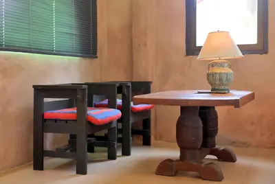 a table with two chairs and a table with a lamp on it at Villa Kamala Beach in Kamala Beach