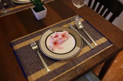 a table with a plate with a flower on it at Surin House in Surin Beach