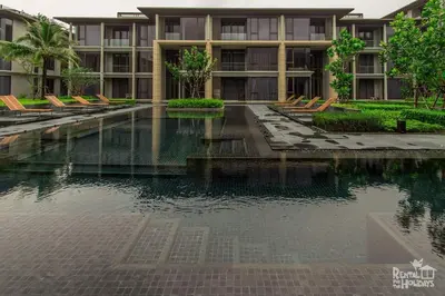 a swimming pool in front of a building at Baan Mai Khao Condominium in Mai Khao Beach
