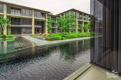 an external view of an apartment complex with a body of water at Baan Mai Khao Condominium in Mai Khao Beach