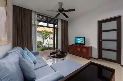a living room with a blue couch and a television at VILLA ARU Private Pool 3 min to Naiharn Beach in Nai Harn Beach