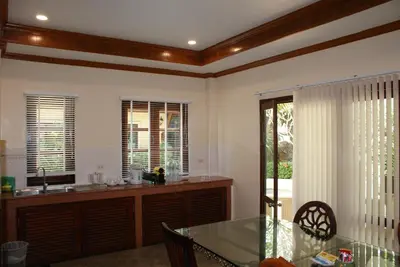 a dining room with a table and a kitchen at Prince Edouard Apartments & Resort Patong Beach Phuket in Patong Beach