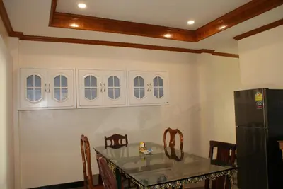 a dining room with a table and a refrigerator at Prince Edouard Apartments & Resort Patong Beach Phuket in Patong Beach