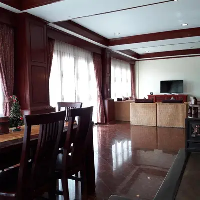 a living room with a table and chairs and a television at Prince Edouard Apartments & Resort Patong Beach Phuket in Patong Beach