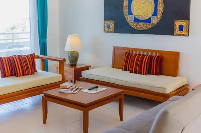 a living room with two beds and a coffee table at Waterfront Suites Phuket by Centara in Karon Beach