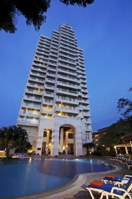 a large white building with a pool in front of it at Waterfront Suites Phuket by Centara in Karon Beach