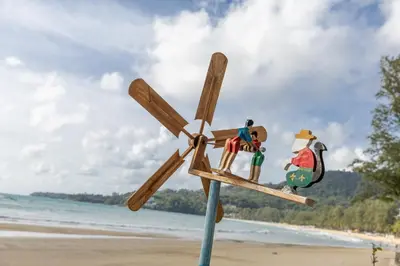 a wooden toy airplane on a pole on the beach at Kamala Dreams in Kamala Beach