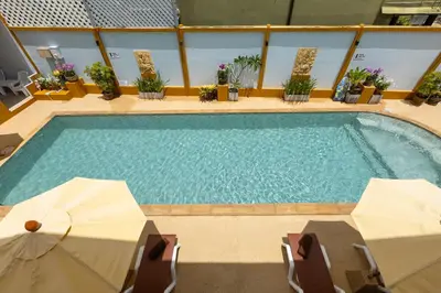 a large swimming pool with two tables and chairs at Kamala Dreams in Kamala Beach