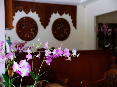 a vase of purple flowers in a room at The Orchid House - SHA Extra Plus in Kata Beach
