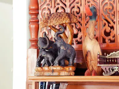 a statue of elephants holding an umbrella on a shelf at The Orchid House - SHA Extra Plus in Kata Beach